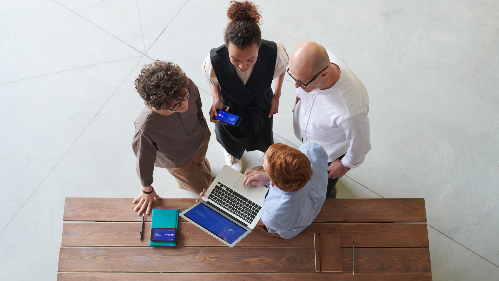 fyra medarbetare som står vid ett bord och planerar